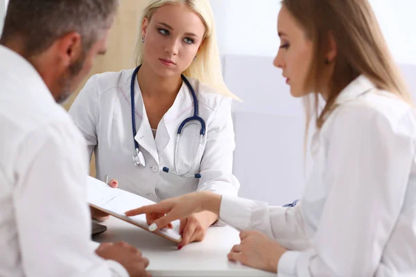 Female family doctor listen carefully young couple Stock Image