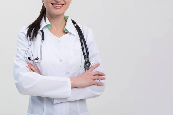 Donna sorridente medico armatura primo piano su grigio — Foto Stock