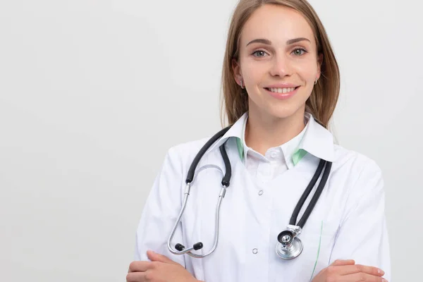 Mujer sonriente médico armcross retrato en gris — Foto de Stock