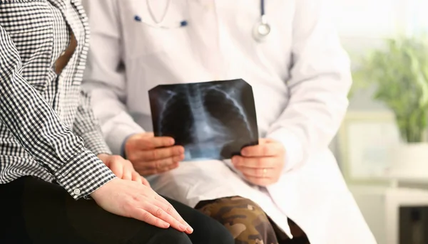Doktor trzyma pacjenta rentgenowskie i raporty złe wieści — Zdjęcie stockowe
