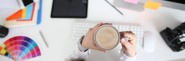 Happy woman holding a cup with latte in