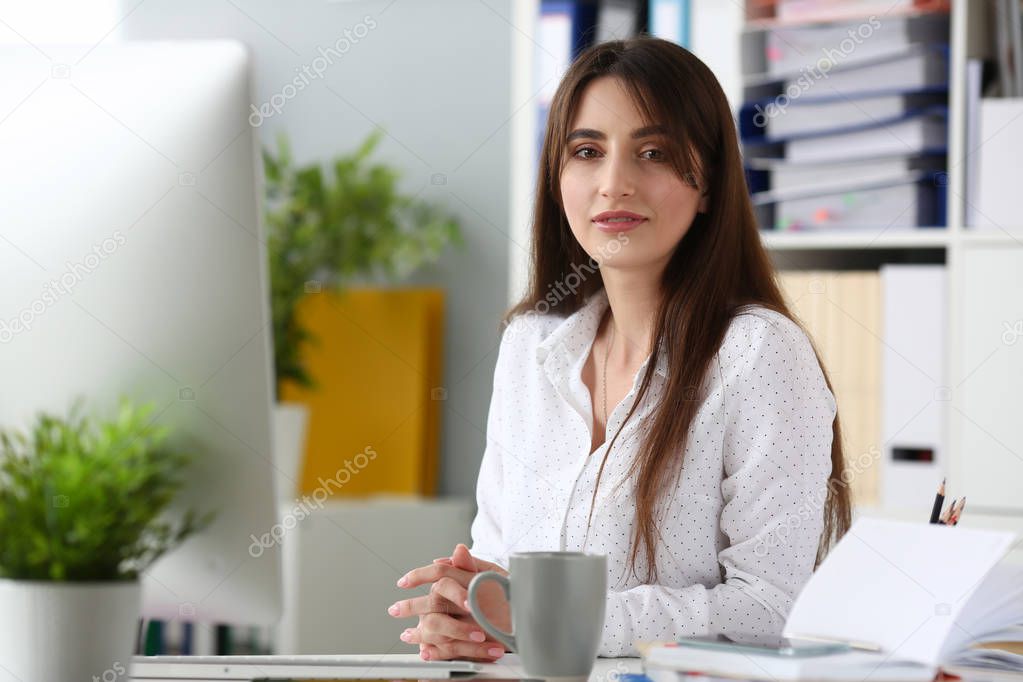 Smiling businesswoman portrait sit table aganist