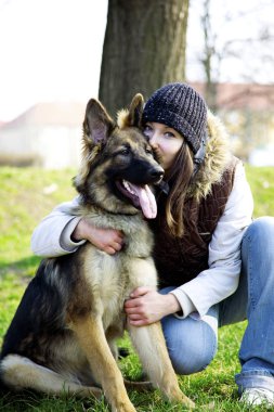 A Happy, Genç Kadın Sevimli Alman Çoban Köpeği Huging, Sonbahar, Sonbahar zaman Parkta Çoban Köpeği. Arkadaşlığın Güzel Bir Portresi.