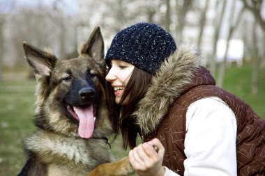 Sevimli Bir Alman Çoban Köpeği, Çoban Köpeği Portresi. Güzel, Genç Bir Kadın Küçük Bir Köpek Yavrusuna Sarılıyor. Güzel bir arkadaşlık portresi. Sonbahar, Sonbahar zamanında ateş.