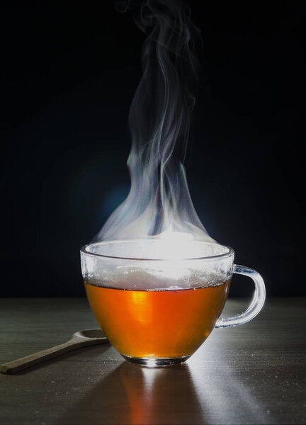 glass cup with tea infusion, on black background with label to write text