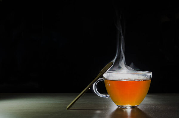 glass cup with tea infusion, on black background with label to write text