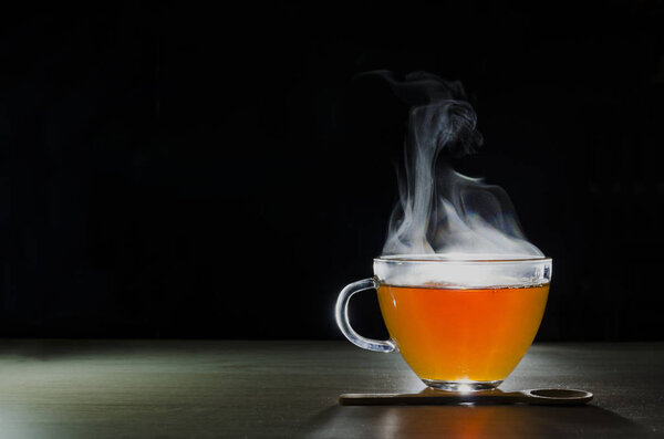 glass cup with tea infusion, on black background with label to write text