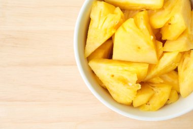 Ananas ahşap bir masa yerleştirilen bir plaka üzerinde.