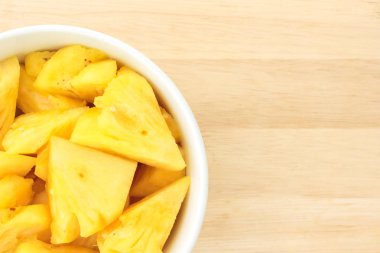 Ananas ahşap bir masa yerleştirilen bir plaka üzerinde.