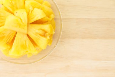 Ananas ahşap bir masa yerleştirilen bir plaka üzerinde.