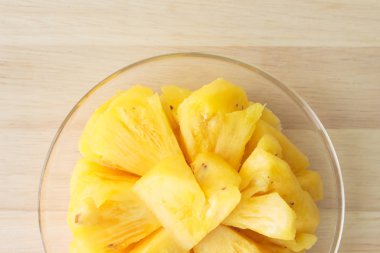 Ahşap bir masa yerleştirilen bir plaka üzerinde dilim ananas.