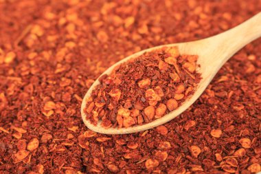 Kırmızı arkaplanda kırmızı biber kaşığı