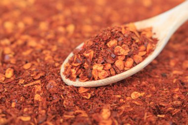 Kırmızı arkaplanda kırmızı biber kaşığı