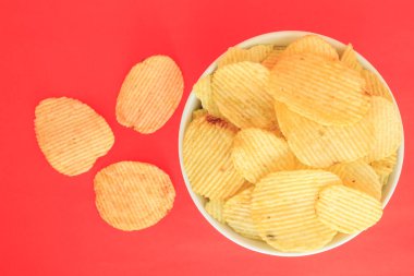 abur cubur sağlıksız gıda kase kırmızı zemin üzerine gevrek patates cips