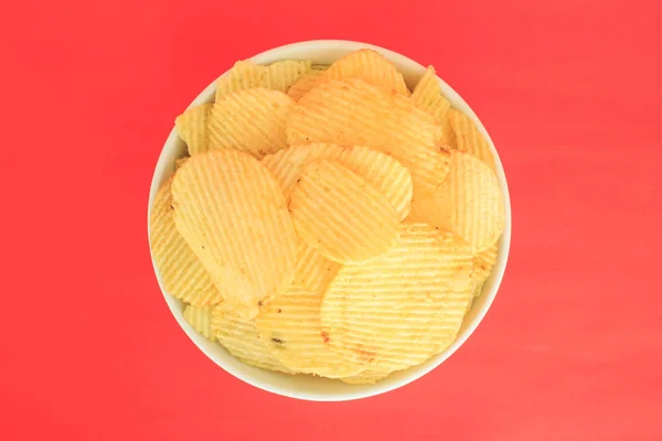Krispig Potatis Chips Skräpmat Ohälsosam Mat Skål Röd Bakgrund — Stockfoto