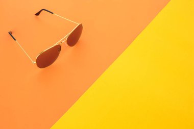 turuncu ve sarı renkli arka plan üzerinde güneş gözlüğü