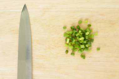 Doğa gıda ahşap kesim tahta zemin üzerine yeşil soğan kesilerek frenk soğanı bıçak