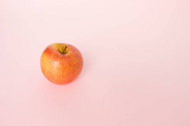 Pembe bir arka plan üzerinde kırmızı elma