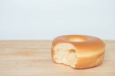 Beyaz arka plan üzerinde ahşap masaya çörek üzerinde diş izleri