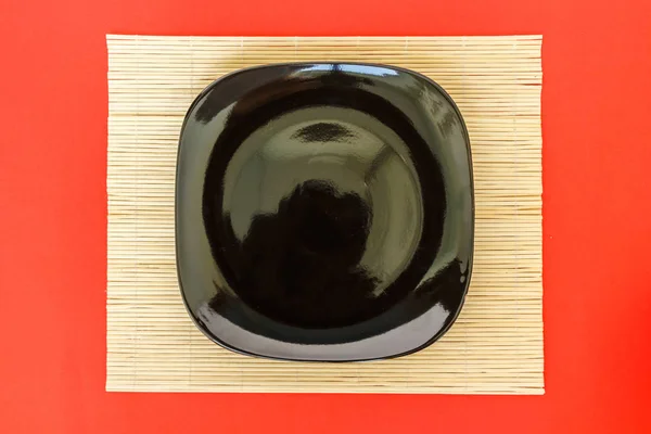 Μαύρη Πιάτο Άδειο Μπαμπού Χαλί Κόκκινο Φόντο — Φωτογραφία Αρχείου