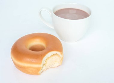 Çörek ve fincan kakao içki beyaz arka plan üzerinde ısırık izleri