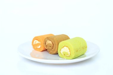 beyaz zemin üzerine yerleştirilmiş beyaz atışında yeşil çikolatalı turuncu kek.