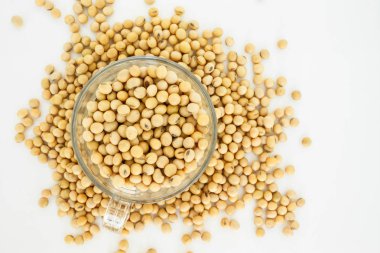 soya fasulyesi üzerinde cam bardakta beyaz arka plan üstten görünüm.