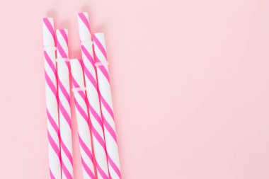 Pembe arka planda pembe çizgili pipetler