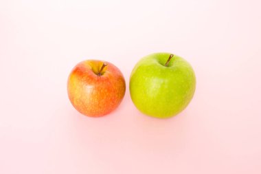 kırmızı elma ve pembe bir arka plan üzerinde yeşil elma