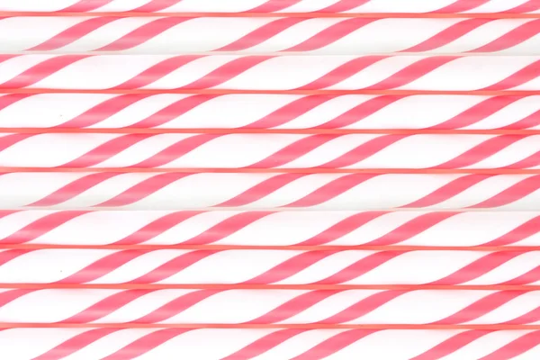 Striped drink straws in red pattern background.