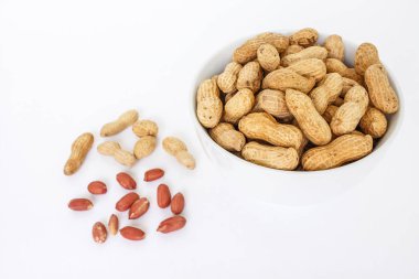 Beyaz arka plan üzerinde beyaz kase üst görünümünde fıstık kazık