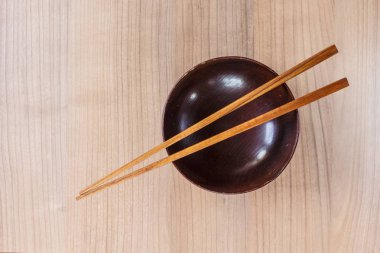 masada ahşap kase ve chopsticks ahşap üstten görünüm.