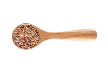 Brown flax seed in spoon on white background. clipart