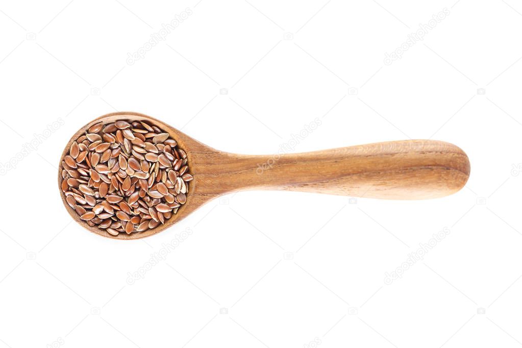 Brown flax seed in spoon on white background.