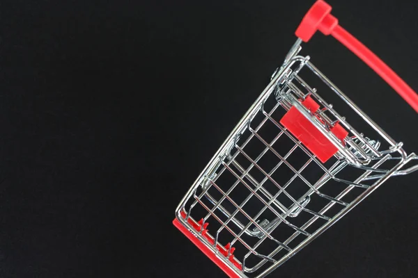 red shopping cart top view on black background.