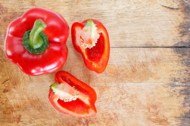 kırmızı dolmalık biber ahşap kesme tahtası arka plan üzerinde parçalar halinde kesilmiş.