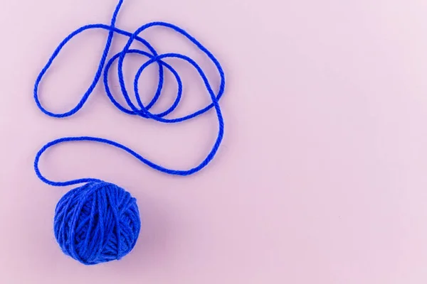 yarn color blue on pink background.