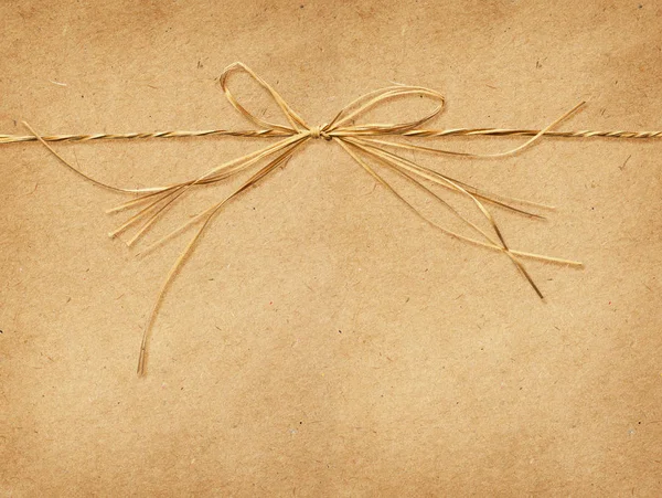 Raffia-Schleife auf Bastelpapier gebunden — Stockfoto