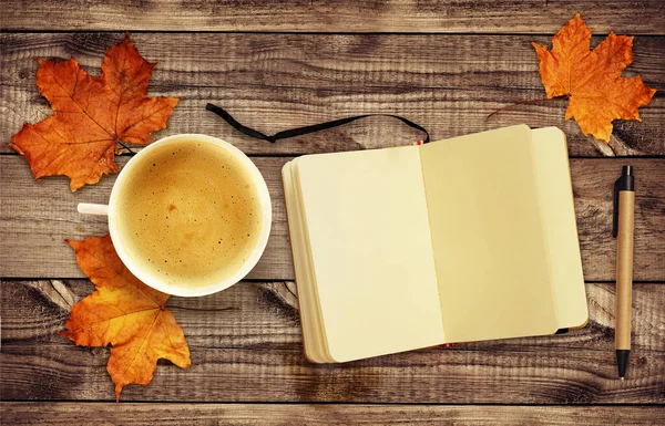 一杯咖啡 秋天干叶 记事本和一支钢笔 木制背景 顶部视图 平躺在床上 — 图库照片