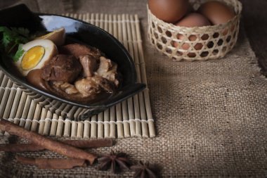 haşlanmış yumurta ve domuz siyah kase ve baharat önüne yerleştirin ve ahşap elek ve çuval ve ahşap arka plan arka sepet yumurta yer