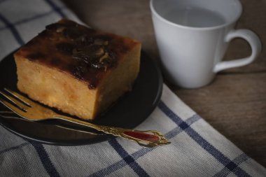 Mung fasulye daire siyah plaka koymak ile Tay muhallebi var altın çatal siyah plaka ve beyaz Kupası yer arka masa örtüsü ve ahşap zemin üzerine yerleştirin