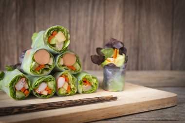 Rulo salata yerleştirilmiş ahşap bir masaya önüne yerleştirilen yemek çubukları ile