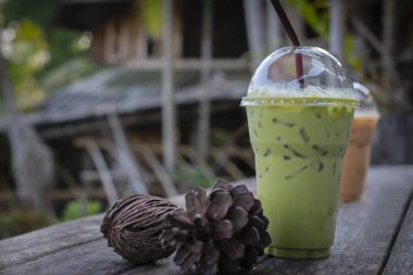 Buzlu süt yeşil çay içecek ile kurutulmuş çam kozalakları ahşap tablo 