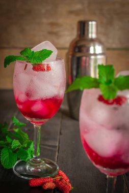 Taze Buz Dut Soda içecek ahşap masada dut, yapraklar, kokteyl shaker ve aynı nesne etrafında yerleştirilir vardır.