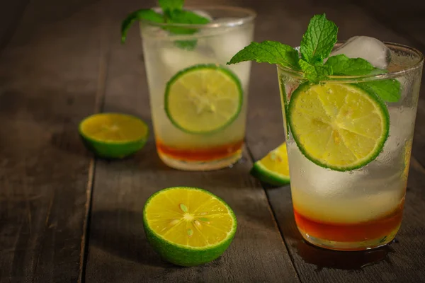 Fresh Ice Honey Lemon soda drink on the wood table there are lemon slice and same object placed around.