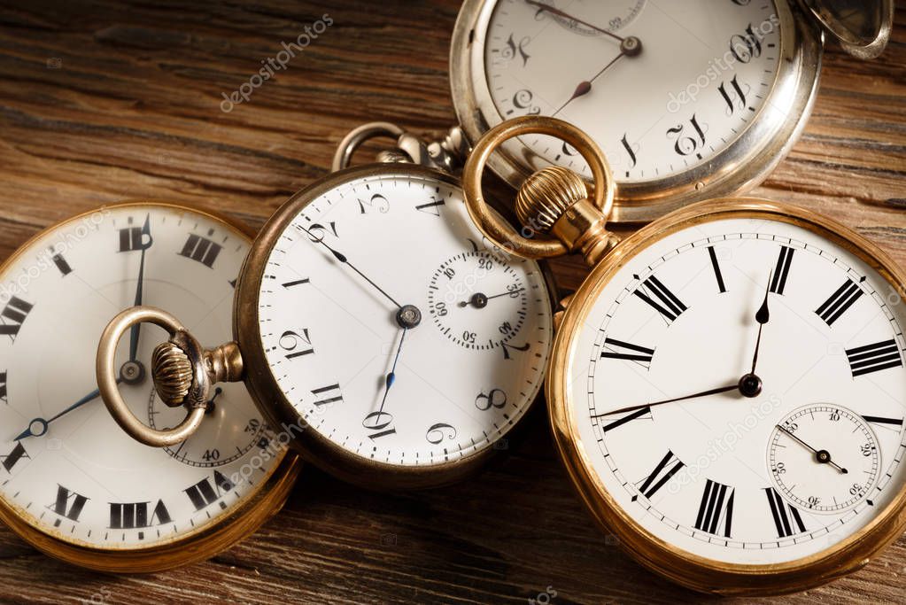 vintage pocket watches on aged wood table