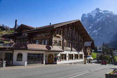 Grindelwald Berne, İsviçre - Nisan 24:Hotels ve dükkanlar ilk zirve teleferik, Nisan Grindelwald Tren İstasyonu'na giden yolda 24,2018, Bern, İsviçre. Oteller ve mağazalar geliyor