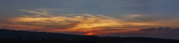 Orange sunrise and cloud over silhouette mountain in panorama view