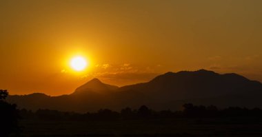 Akşam siluet dağ ve pirinç alan üzerinden günbatımı