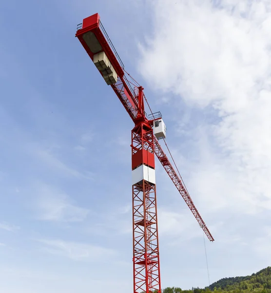 Großer roter Kran auf Baustelle mit weißer Wolke und blauem Himmel — Stockfoto